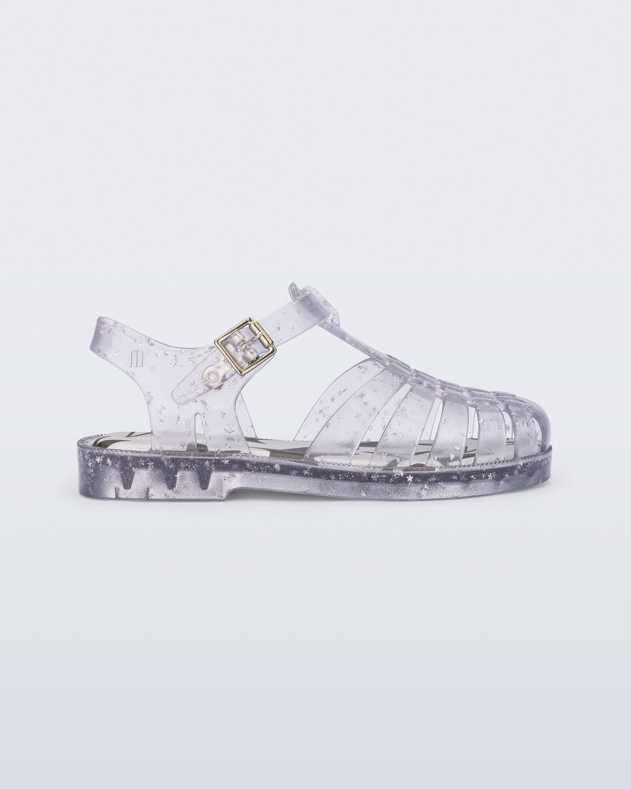 Side view of a clear Possession kids sandal with star glitter