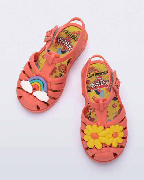 Top view of a red baby Possession + Play Doh sandal with one shoe having a daisy and the other a rainbow on the upper