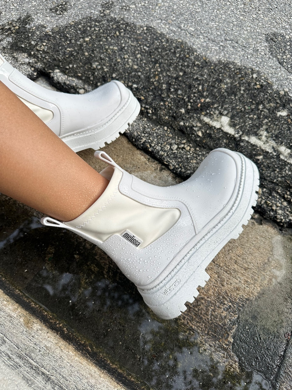 model wearing the white drip boot in rain