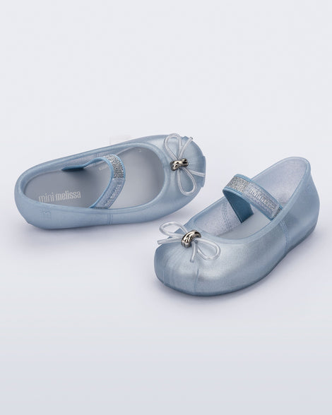 Side and angled view of a pair of pearly blue Sophie baby ballerina flats with bow