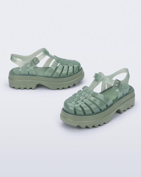 Side and angled view of a pair of green Possession Platform II sandals.