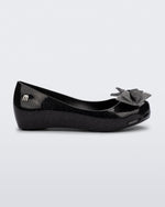 Side view of a glitter black Ultragirl Sweet kids ballerina flat with bow