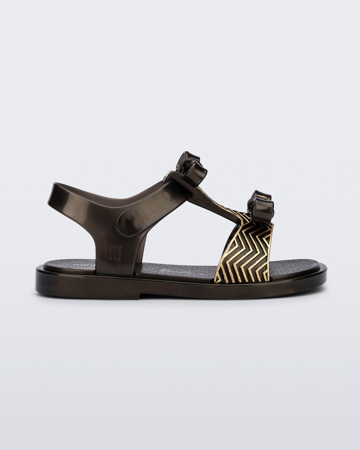 Side view of a black baby Dream Sandal with two bows and gold detail on strap