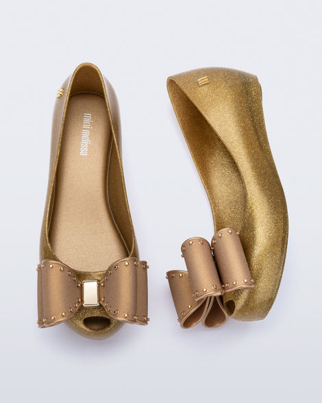 Top and side view of a pair of pearly beige kids Ultragirl Classic Bow kids flats