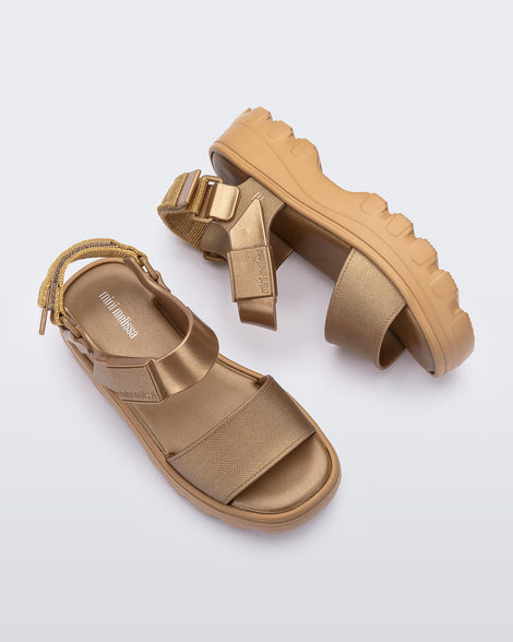 Top and side view of a pair of gold kids Kick Off Sandals