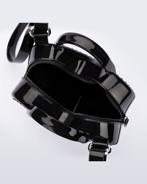 Top view of a black Heartbeat bag with small handles and longer strap.