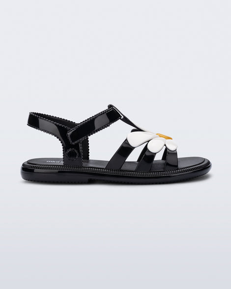 Side view of a kids black and white Hip Bloomy sandal