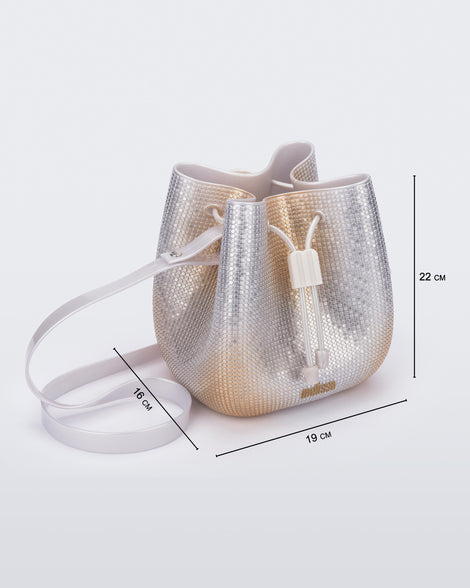 Angled view of a silver/gold Lux bucket bag with drawstring and strap with bag measurements of 19cm x 16cm x 22cm