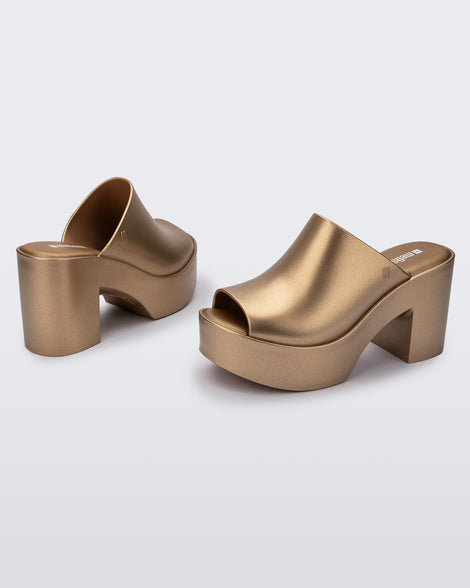 Angled view of a pair of gold Mule Hype Platforms