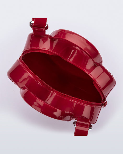 Top view of a red Heartbeat bag with small handles and longer strap.