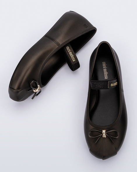 Side and top view of a pair of metallic black Sophie kids ballerina flats with bow