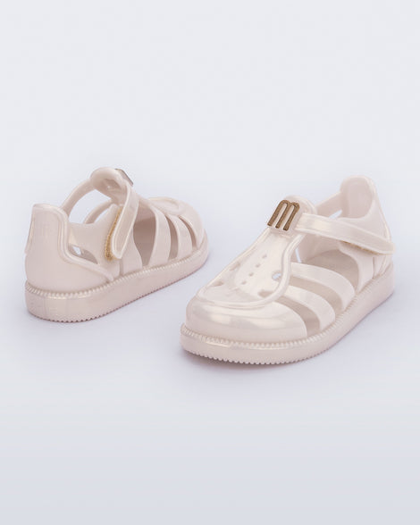 Back and angled view of a pair of metallic beige baby Hip Daydream sandals