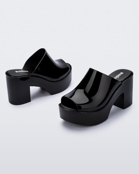 Angled view of a pair of black Mule Hype heel platforms