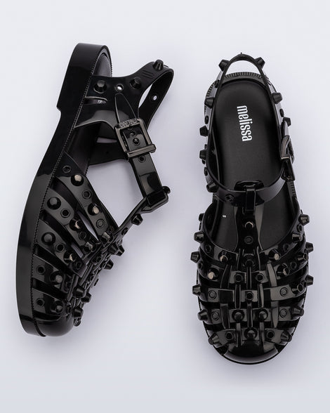 Side and top view of a pair of black Possession Studs fisherman sandals with silver studs.