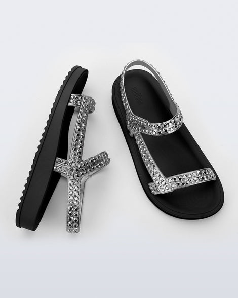 Side and top view of a pair of black Lust sandals with silver strap