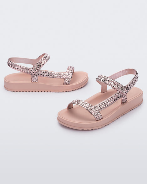 Side and angled view of a pair of pink Lust sandals with rose gold strap