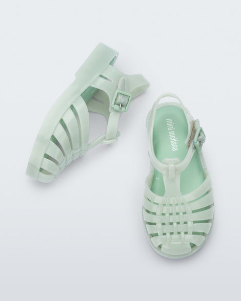 Top and angled view of a pair of light green baby Possession sandals.
