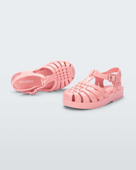 Top and side view of a pair of light pink baby Possession sandals.
