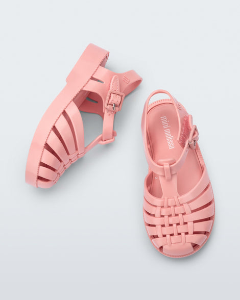 Top and angled view of a pair of light pink baby Possession sandals.
