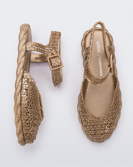 Side and top view of a pair of gold Melissa Papel Espadrille Campana sandals with braided sole detail and ankle strap