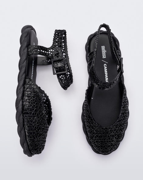 Side and top view of a pair of black Melissa Papel Espadrille Campana sandals with braided sole detail and ankle strap