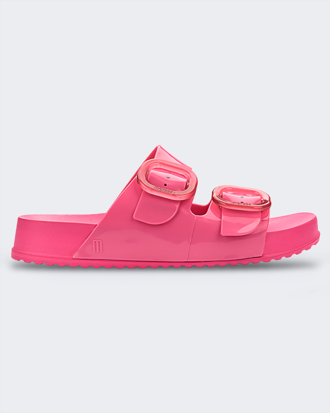 An outer side view of a pink Melissa Cozy slide on a gray background