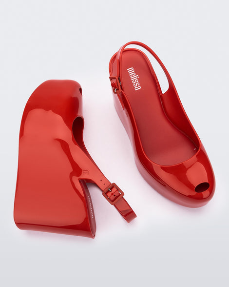 Side and top view of a pair of red Melissa Groovy wedge platform slingback heels with peep toe.