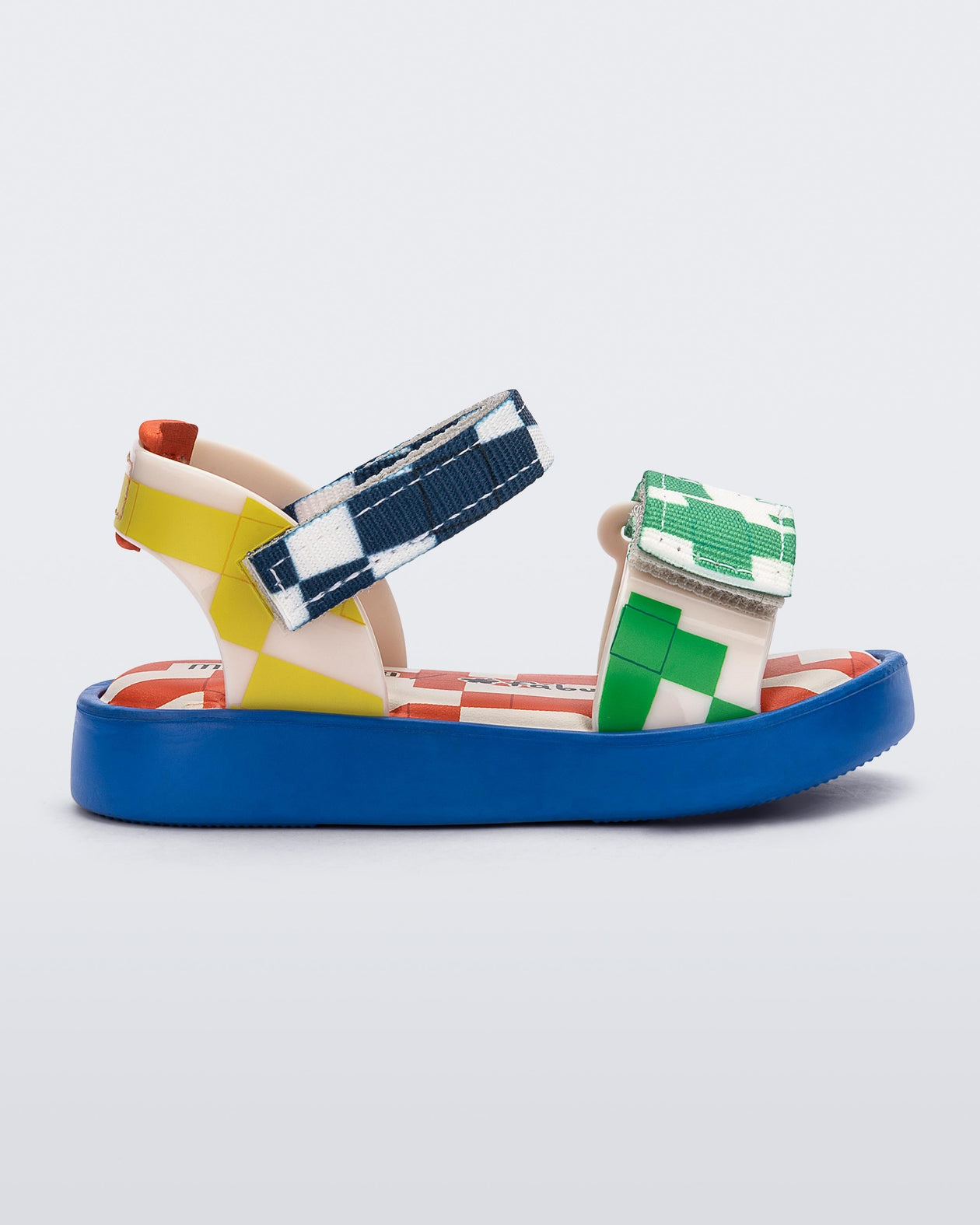 Side view of a blue, yellow, green and beige patterned Mini Melissa Pula Pula + Fabula sandal.