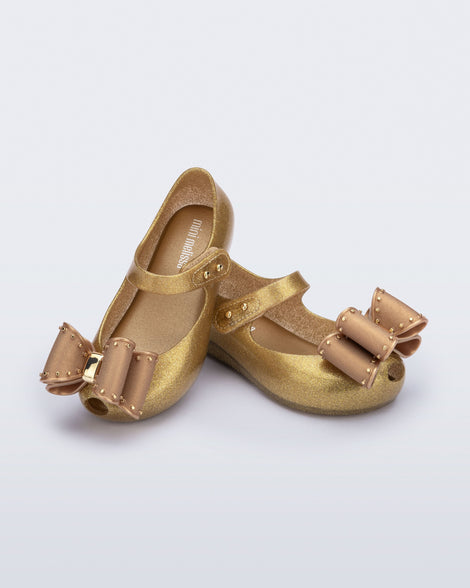 Angled view of a pair of pearly beige baby Ultragirl Classic Bow flats