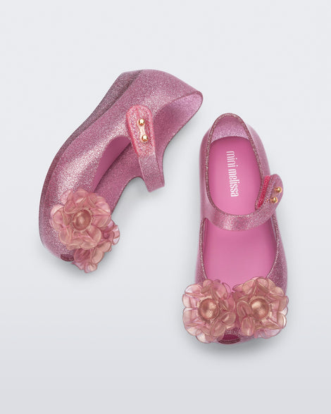 Top and side view of a pair of glitter pink baby Ultragirl Springtime flats