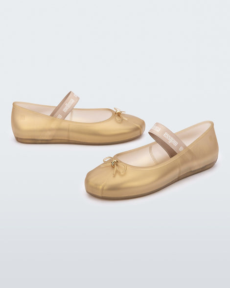 Side angled view of a pair of gold Sophie flats.