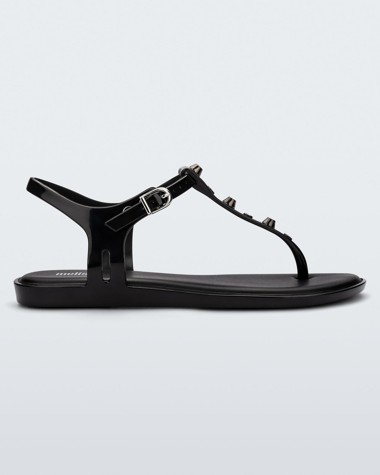 Side view of a black Melissa Solar studs sandal with gold studded t-strap and gold buckle.