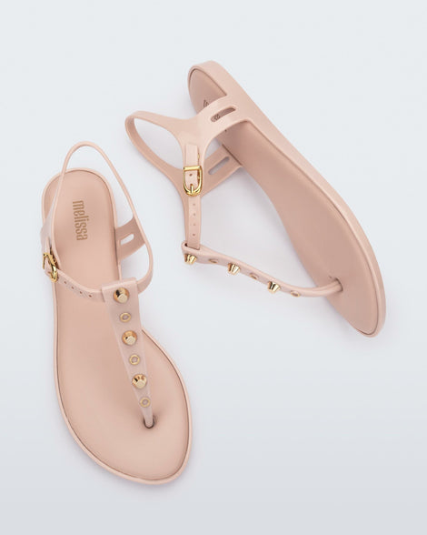 Top and side view of a pair of pink Melissa Solar studs sandals with gold studded t-strap and gold buckle.