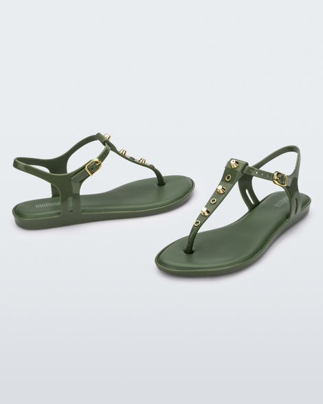 Angled and side view of a pair of green Melissa Solar studs sandals with gold studded t-strap and gold buckle.