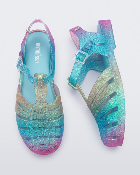 Top and side view of a pair of blue and pink glitter Possession sandals.