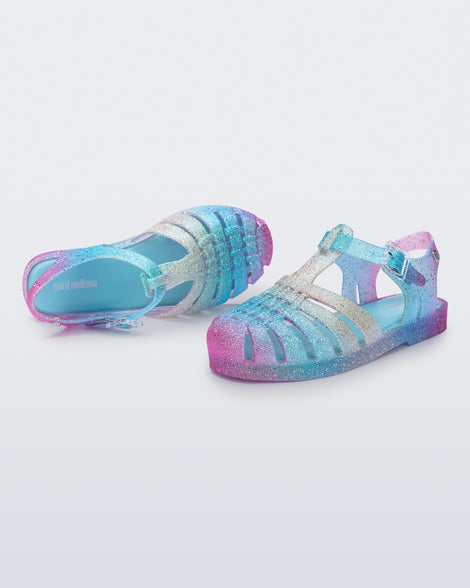 Top and side view of a pair of blue and pink glitter kids sandals Possession sandals.