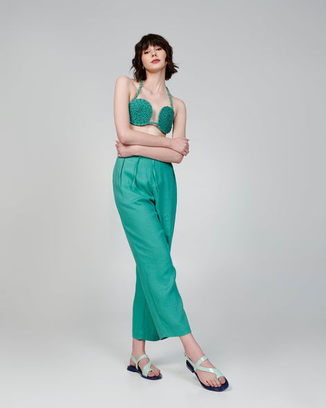 Model in a teal outfit wearing a pair of green Cassie sandals.