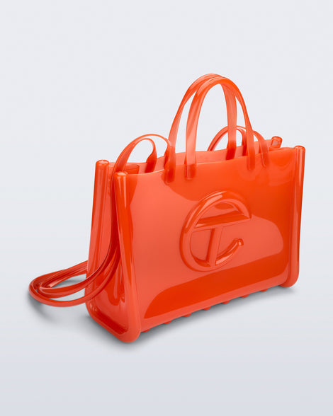 Angled view of the orange Large Jelly Shopper x Telfar bag