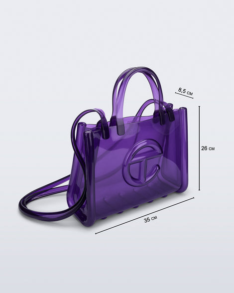 Angled view of the purple Medium Jelly Shopper x Telfar bag with dimensions: 35 cm x 8.5 cm x 26 cm