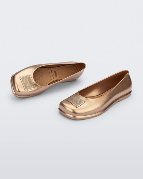 Side and angled view of a pair of metallic gold Ruby + Marc Jacobs flats