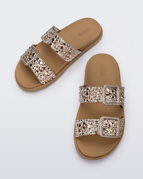 Top view of a pair of beige Lust Slide with metallic buckle straps