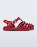 Side view of a red Possession Studs fisherman sandal with silver studs.