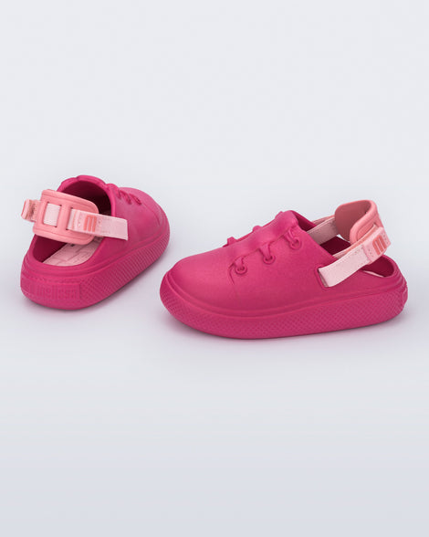 Side and back view of a pair of pink with back strap Charlie baby sneakers