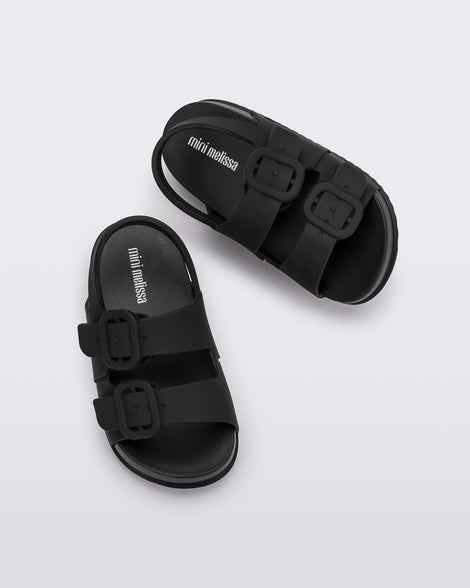 Top view of a pair of matte black Mini Melissa Cozy sandals with two front straps with buckle detail