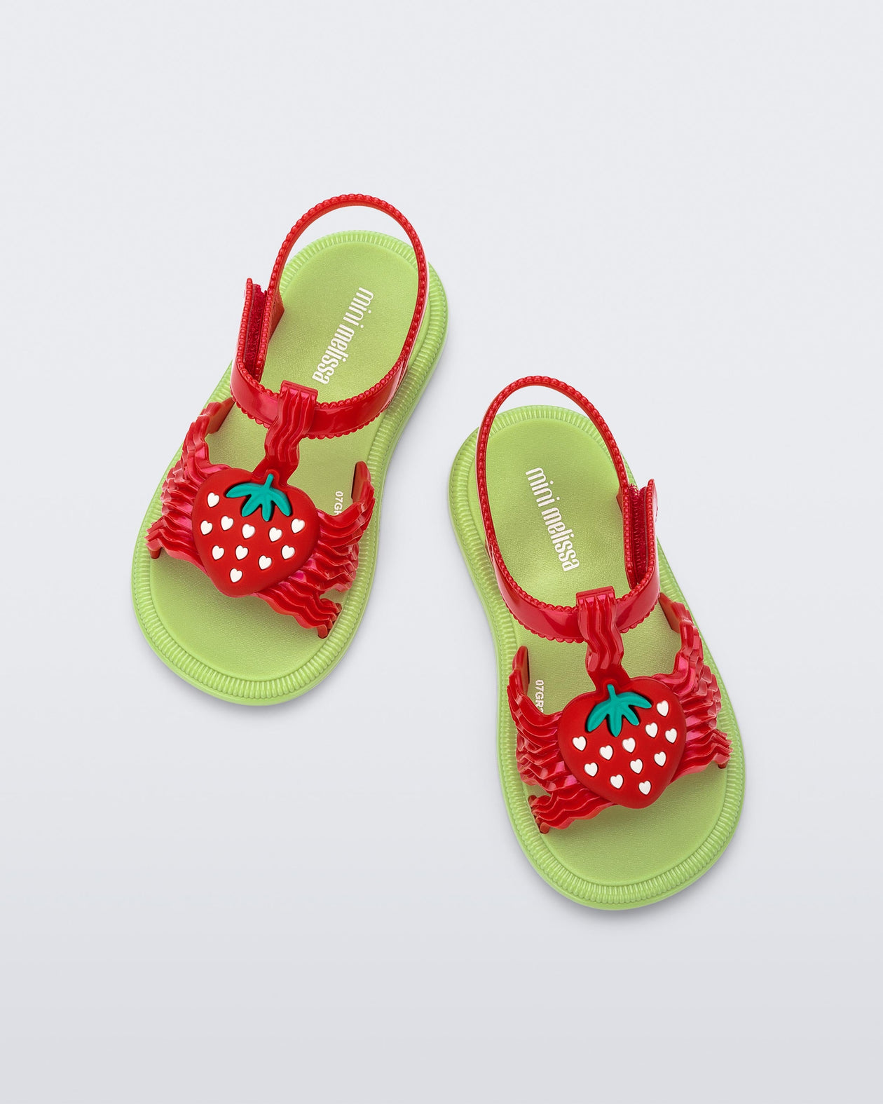 Top view of a pair of red baby Hip Sandals with red strawberry and green sole