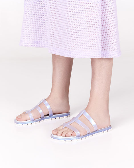 Model's legs wearing a pair of pearly blue Path adult sandals with  blue sole