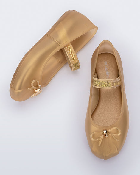 Side and top view of a pair of pearly beige Sophie kids ballerina flats with bow