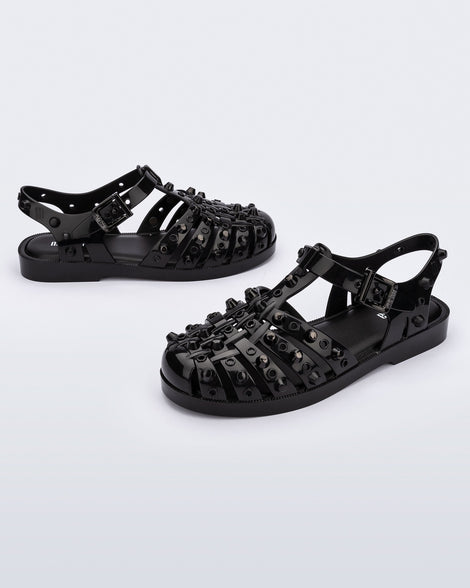 Side and angled view of a pair of black Possession Studs fisherman sandals with silver studs.