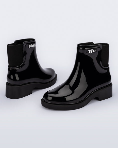 Back and angled view of a pair of black Chelsea Boots.