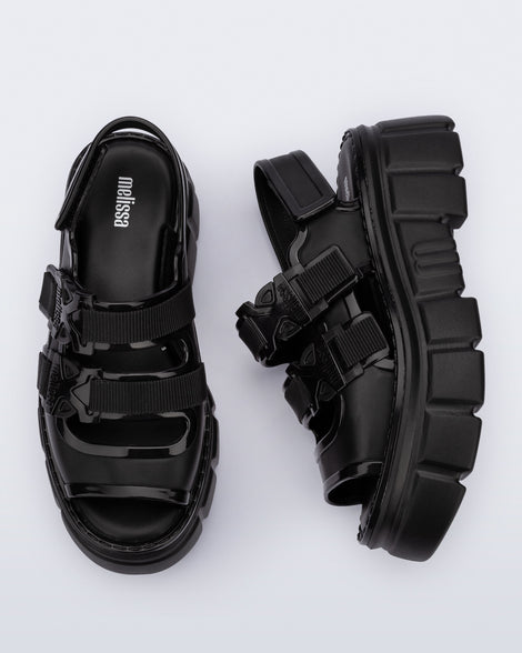 Side and top view of a pair of black Rebel platform Sandals with back strap.